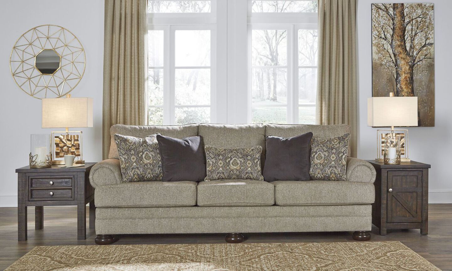 living room with couch, two side tables, and a round, gold mirror and painting on the wall